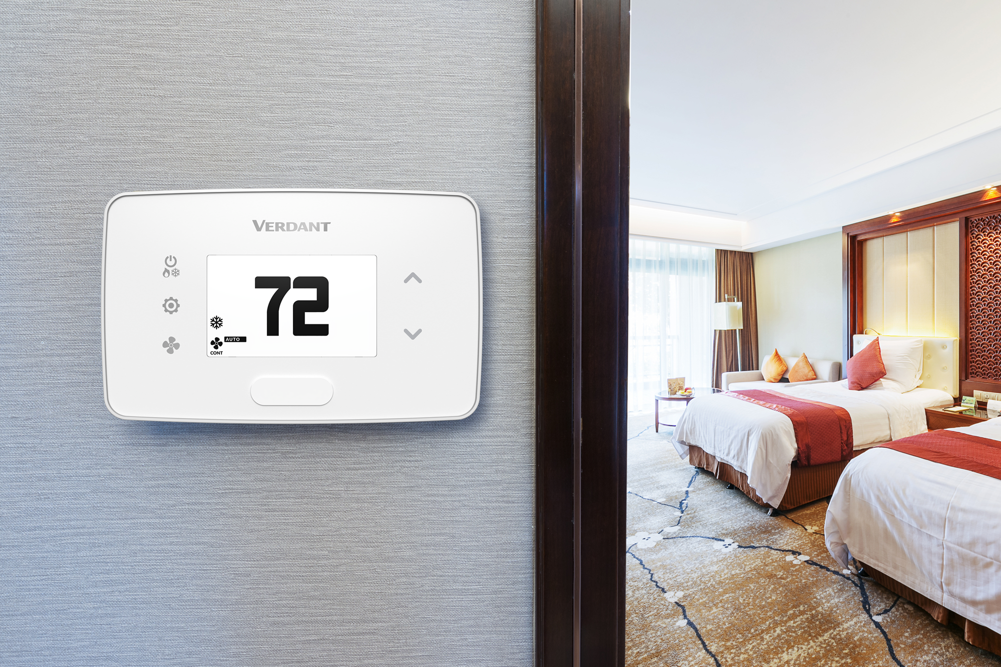 A Verdant VX4 wired smart thermostat (in black) installed in a hotel room to improve energy management
