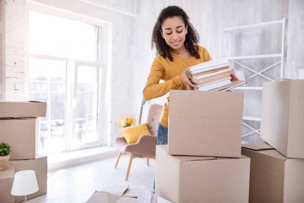 a person packing up belongings into several boxes