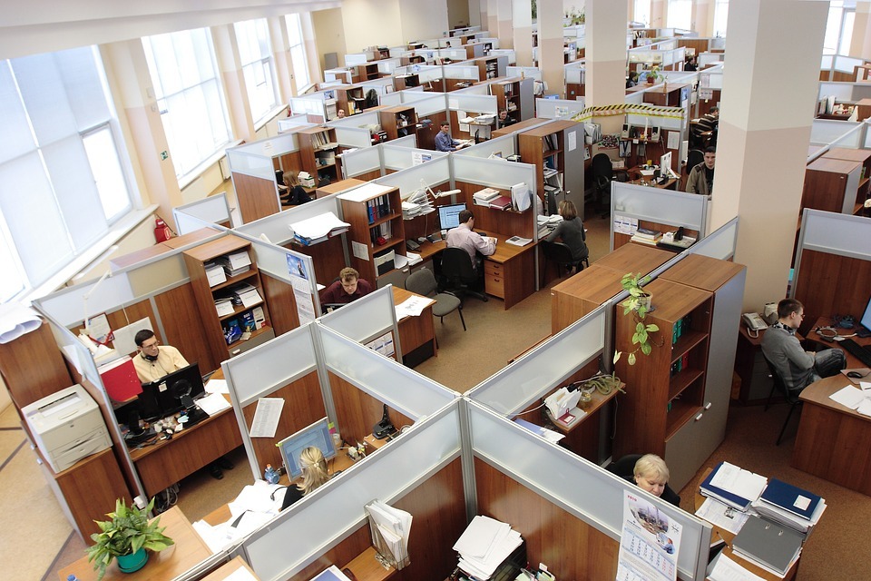 Overhead of an office environment with many cubicles and several people working